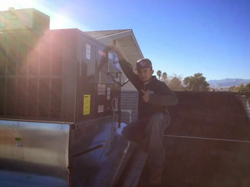 HVAC technician performing AC Tune-Up on a rooftop unit in Pinole